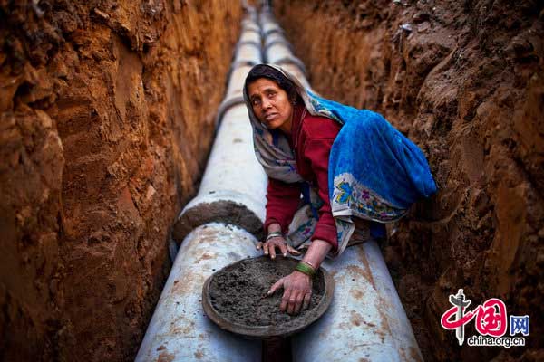 An Indian woman works at a construction project in front of the Jawaharlal Nehru Stadium on February 01, 2010 in New Delhi, India. 