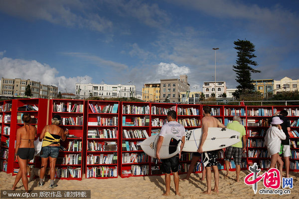 Beach goers select books from 30 red Ikea Billy bookcases lined up to form the world&apos;s longest outdoor bookcase to celebrate the 30th birthday of the brand&apos;s signature furniture piece, at Bondi Beach on January 31, 2010 in Sydney, Australia.