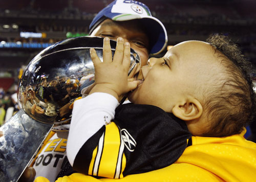 Pittsburgh Steelers' Marvell Smith holds his son Kingston and the Vince Lombardi Trophy after his team defeated the Arizona Cardinals to win the NFL's Super Bowl XLIII football game in Tampa, Florida February 1, 2009. (Xinhua/Reuters File Photo)