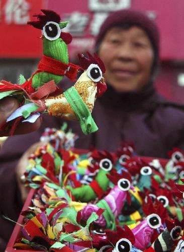 A folk craftswoman shows her handmade cloth dolls of Spring Cock in Matou Township of Tancheng County, east China's Shandong Province, February 3, 2010, one day ahead of Spring Begins. [Xinhua photo]