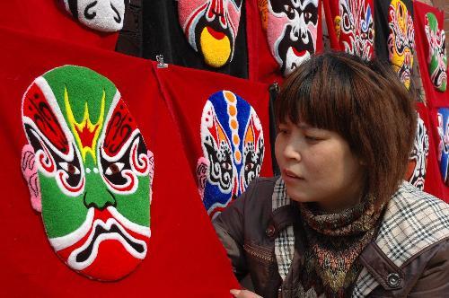 Villager Wang Jinping (C) shows her 30-meter-long embroidery work at Sanjiazhuang Village of Guowang Township in Fengxiang County, northwest China's Shaanxi Province, February 4, 2010.