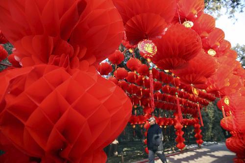 A pedestrian walks through the long corridor decorated with full range of florid red lanterns inside the Ditan (Altar of the Earth) Park, as the festival atmosphere for the 25th Spring Festival Temple Fair slated from February 13 to 20, at Ditan Park is drumming up, in Beijing, February 4, 2010. 