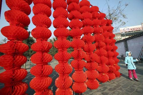 A little girl saunters by a range of florid red lanterns inside the Ditan (Altar of the Earth) Park, as the festival atmosphere for the 25th Spring Festival Temple Fair, slated from February 13 to 20, at Ditan Park is drumming up, in Beijing, February 4, 2010.