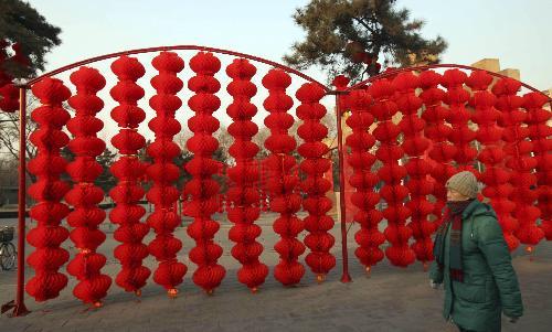 A pedestrian walks past the full range of florid red lanterns inside the Ditan (Altar of the Earth) Park, as the festival atmosphere for the 25th Spring Festival Temple Fair, slated from February 13 to 20, at Ditan Park is drumming up, in Beijing, February 4, 2010.