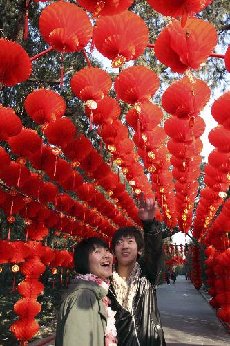 A young pair enjoy the sightseeing of the long corridor decorated with full range of florid red lanterns inside the Ditan (Altar of the Earth) Park, as the festival atmosphere for the 25th Spring Festival Temple Fair, slated from February 13 to 20, at Ditan Park is drumming up, in Beijing, February 4, 2010.