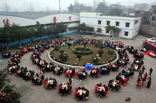 Workers enjoy a group dinner for Xiaonian, the festival that falls on the 23rd or 24th day of the 12th month of the Chinese traditional lunar calendar, in a local company in Guang'an, southwest China's Sichuan Province, Feb. 6, 2010. A local company gave a banquet to its nearly 1,000 migrant workers in the honor of Xiaonian. (Xinhua