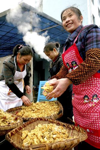 Cooks prepare for a group dinner for Xiaonian, the festival that falls on the 23rd or 24th day of the 12th month of the Chinese traditional lunar calendar, in a local company in Guang'an, southwest China's Sichuan Province, Feb. 6, 2010. A local company gave a banquet to its nearly 1,000 migrant workers in the honor of Xiaonian. (Xinhua/Qiu Haiying)