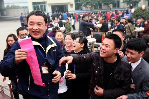 Workers play guessing games during a group dinner for Xiaonian, the festival that falls on the 23rd or 24th day of the 12th month of the Chinese traditional lunar calendar, in a local company in Guang'an, southwest China's Sichuan Province, Feb. 6, 2010. A local company gave a banquet to its nearly 1,000 migrant workers in the honor of Xiaonian. (Xinhua