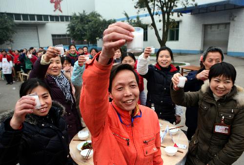 Workers enjoy a group dinner for Xiaonian, the festival that falls on the 23rd or 24th day of the 12th month of the Chinese traditional lunar calendar, in a local company in Guang'an, southwest China's Sichuan Province, Feb. 6, 2010. A local company gave a banquet to its nearly 1,000 migrant workers in the honor of Xiaonian. (Xinhua/Qiu Haiying)