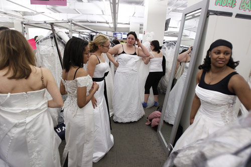 Shoppers wait their turn to look in a mirror Filene&apos;s Basement during a &apos;Running of the Brides&apos; bridal dress sale in New York February 5, 2010. [Xinhua/Reuters]