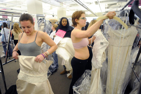 Shopper try on wedding dresses at Filene&apos;s Basement during a &apos;Running of the Brides&apos; bridal dress sale in New York February 5, 2010. [Xinhua/Reuters]