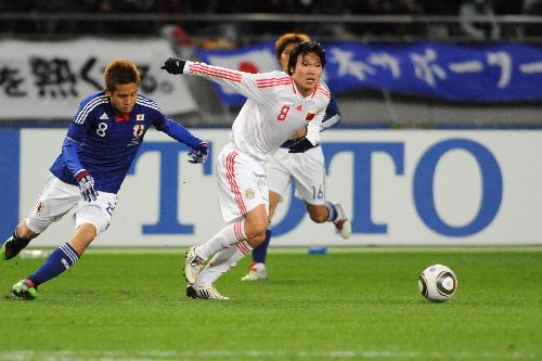 Deng Zhuoxiang (R) of China competes during the match between China and Japan of the East Asian Football Championship 2010 in Tokyo, capital of Japan, Feb. 6, 2010. The match ended with a draw 0-0. (Xinhua/Hua Yi)