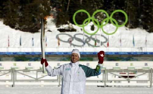 Former Canadian field hockey Olympian Deb Whitten holds the Olympic Torch at the biathlon venue in Whistler Olympic Park prior to the Vancouver 2010 Winter Olympics in British Columbia February 5, 2010. (Xinhua/Reuters) 