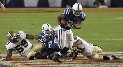Indianapolis Colts running back Joseph Addai runs with the ball as New Orleans Saints defensive tackle Anthony Hargrove (L) and middle linebacker Jonathan Vilma (R) fail to stop him in the first quarter during the NFL's Super Bowl XLIV football game in Miami, Florida, February 7, 2010. Saints stuns Colts 31-17 to claim title of first Super Bowl.(Xinhua/Reuters Photo)