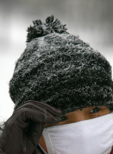 A passersby walks in the snow in Harbin, northeast China&apos;s Heilongjiang Province, on Feb. 7, 2010. A snowfall hit the city on Sunday, which local people called an auspicious greeting for the upcoming Chinese Lunar New Year. [Xinhua]