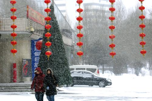 People walk in the snow in Harbin, northeast China&apos;s Heilongjiang Province, on Feb. 7, 2010. A snowfall hit the city on Sunday, which local people called an auspicious greeting for the upcoming Chinese Lunar New Year. [Xinhua]