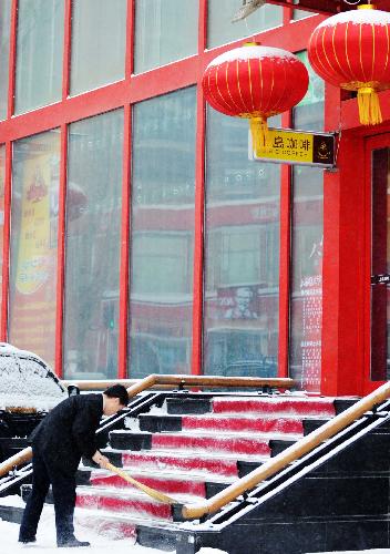 A waiter cleans up the snow in front of a restaurant in Harbin, northeast China&apos;s Heilongjiang Province, on Feb. 7, 2010. A snowfall hit the city on Sunday, which local people called an auspicious greeting for the upcoming Chinese Lunar New Year. [Xinhua]