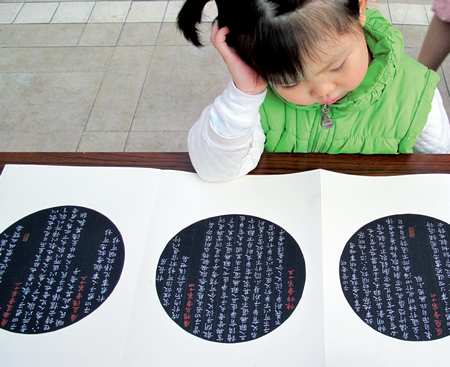 A young girl looks at calligraphy in Jilin.