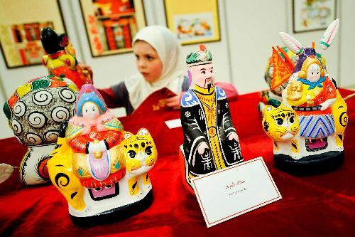 An Eygptian girl looks at a clay figurine featuring a folk custom of the Chinese Spring Festival during the Chinese Culture Week that kicked off in Rihab City on the eastern outskirts of Cairo, capital of Egypt, Feb. 5, 2010.