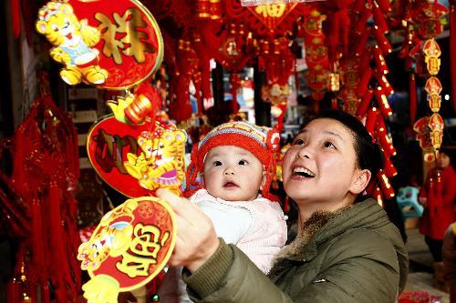 A woman chooses new year decorations at a market in Suining City, southwest China's Sichuan Province, February 6, 2010. [Xinhua photo]