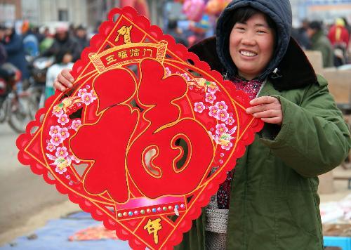 A woman buys decorations at a rural fair in Tancheng County, east China's Shandong Province, February 6, 2010. [Xinhua photo]