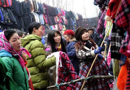 Women buy dresses at a rural fair in Zaozhuang City, east China's Shandong Province, Feb. 6, 2010.