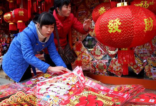 Women choose new year decorations at a shop in Rongshui County, south China's Guangxi Zhuang Autonomous Region of southwest China's Guangxi Zhuang Autonomous Region Feb. 6, 2010. 