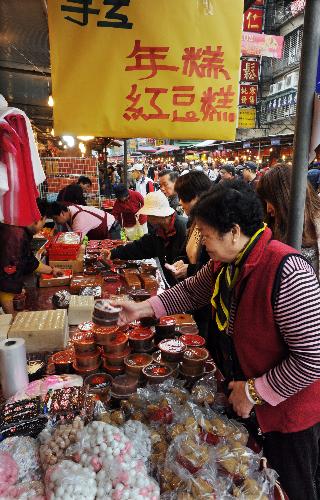 People buy Niangao, a traditional pastry made of glutinous rice that is eaten in the lunar New Year, at a market in Taipei, southeast China's island province of Taiwan, Feb. 7, 2010.