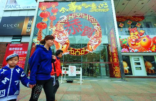 People walk in front of a shopping mall in Fuzhou, capital of southeast China's Fujian Province, Feb. 8, 2010. Chinese people are preparing to celebrate the traditional Chinese New Year, or the Spring Festival, which falls on Feb. 14 this year. (Xinhua