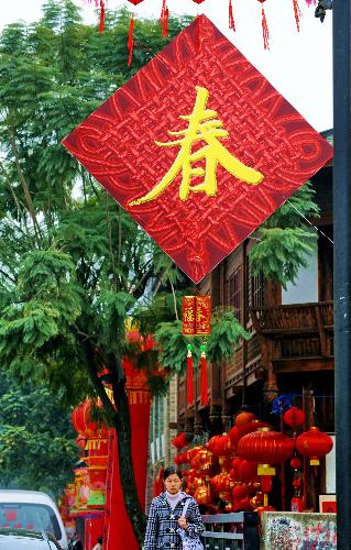 A girl walks at a newly-decorated commercial district in Fuzhou, capital of southeast China's Fujian Province, Feb. 8, 2010. Chinese people are preparing to celebrate the traditional Chinese New Year, or the Spring Festival, which falls on Feb. 14 this year. (Xinhua