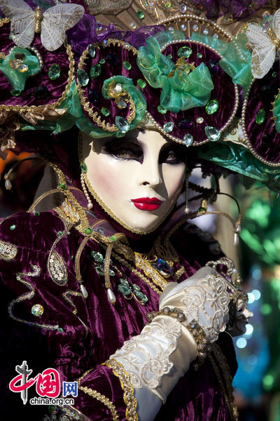 A carnival goer dressed in a costume walks past onlookers at San Marco square in Venice, Italy Feb. 7, 2010, during the annual Venice Carnival. [CRI]