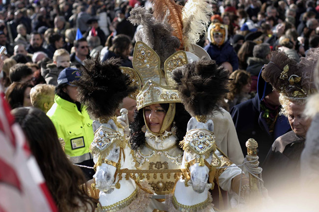 Carnival goers dressed in a costume walk past onlookers at San Marco square in Venice, Italy Feb. 7, 2010, during the annual Venice Carnival. [Xinhua]