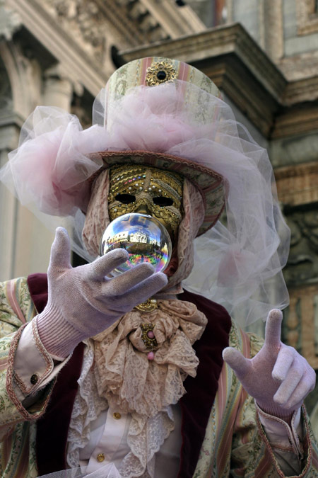 A carnival goer dressed in a costume walks past onlookers at San Marco square in Venice, Italy Feb. 7, 2010, during the annual Venice Carnival. [Xinhua]