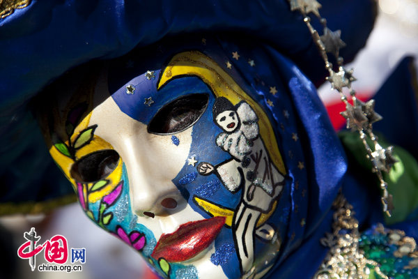 A carnival goer dressed in a costume walks past onlookers at San Marco square in Venice, Italy Feb. 7, 2010, during the annual Venice Carnival. [Xinhua]