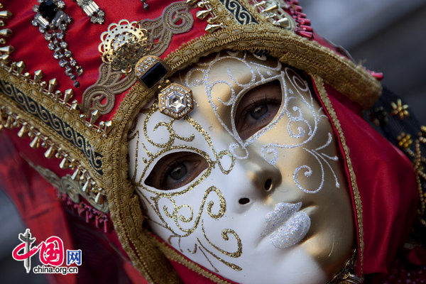 A carnival goer dressed in a costume walks past onlookers at San Marco square in Venice, Italy Feb. 7, 2010, during the annual Venice Carnival. [Xinhua]