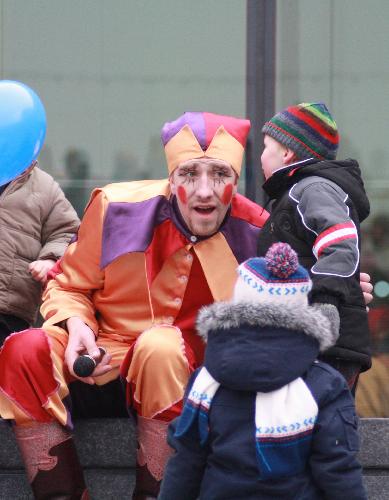 A participant dressed as a clown talks with a kid during the Maslenitsa celebrations at the scoop stage in London, Britain, on Feb. 7, 2010. [Xinhua]