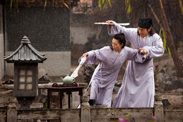 The latest released on-set photos show a very intimate moment shared in the rain between two protagonists. In the film, scholar Tong Bak Fu, played by actor Huang Xiaoming, teaches Zhang Jingchu's Chau Heung how to write.