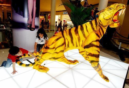 Children touch the tail of a model tiger at Senayan City, a shopping mall in Jakarta, capital of Indonesia, Feb. 8, 2010. Festive decorations are seen in shopping centers in Jakarta as Lunar New Year of the Tiger, that falls on February 14, 2010, approaches. [Xinhua photo]