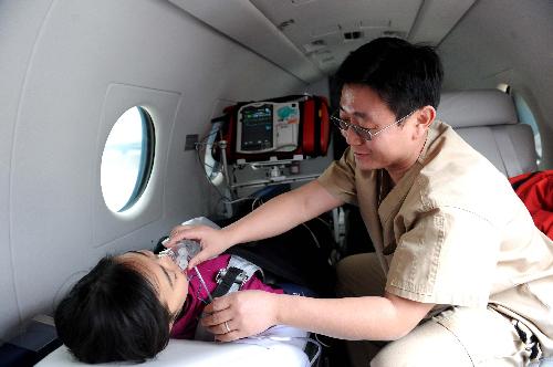 The medical worker of a medical flight service company nurses a 'patient' on the jet during a drilling in north China's Tianjin Municipality, Feb. 9, 2010. (Xinhua