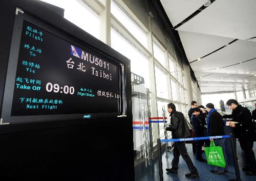 Tourists walk past the boarding gate at Taiyuan Wusu Airport in Taiyuan, north China's Shanxi Province, on Feb. 10, 2010. [Xinhua]