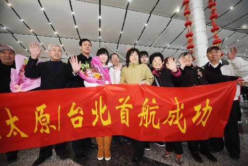 Tourists pose for a group photo before leaving for Taiwan at Taiyuan Wusu Airport in Taiyuan, north China's Shanxi Province, on Feb. 10, 2010. [Xinhua]