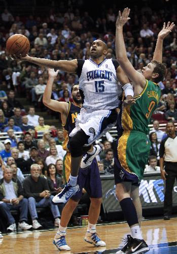 Orlando Magic guard Vince Carter (C) splits New Orleans Hornets forwards' Darius Songaila (R) and Peja Stojakovic as he goes to the basket during second half NBA basketball action in Orlando, Florida February 8, 2010. Magic won 123-117. (Xinhua/Reuters Photo) 