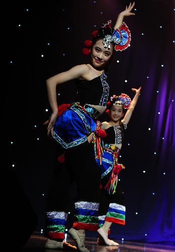 Dancers from the Art Troupe of the High School Affiliated to Renmin University (RDFZ) of China perform dance 'Yi Minority Folklore' in Wellington College, Crowthorne of Berkshire, Britain, February 8, 2010.