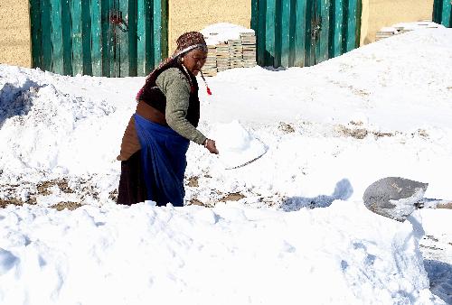 A woman clears snow in Burang of Ngari Prefecture in southwest China's Tibet Autonomous Region, Feb. 10, 2010. Blizzard also hit parts of southwest China's Tibet Autonomous Region since Monday. As of Tuesday night, the Ngari Prefecture had reported 21.7 mm of precipitation and the fresh snow on the ground measured 23 centimeters.