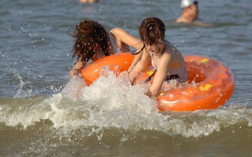 People amuse themselves in the sea in Haikou, capital of south China's Hainan Province, Feb. 10, 2010. According to local weather report, the highest temperature in the province has reached 35 degrees Celsius on Wednesday. A large number of people in Haikou went to the beach to cool themselves down. 