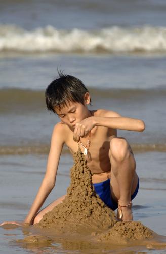 A boy plays with the sands on the beach in Haikou, capital of south China's Hainan Province, Feb. 10, 2010. According to local weather report, the highest temperature in the province has reached 35 degrees Celsius on Wednesday. A large number of people in Haikou went to the beach to cool themselves down. 