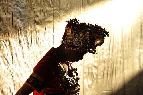 An actress from central China's Hunan Province changes costumes at a makeshift tiring-room in Nairobi, capital of Kenya, February 10, 2010. 