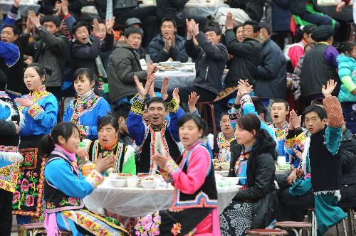 People watch performance during a banquet at a permanent settlement in Qionglai, city of southwest China's Sichuan Province, Feb. 11, 2010. People of the settlement, which was built for those homeless after the earthquake in May 12, 2008, held a banquet Thursday to thank their benefactors ahead of their first Spring Festival in Qionglai.