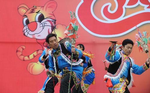 People perform during a banquet at a permanent settlement in Qionglai, city of southwest China's Sichuan Province, Feb. 11, 2010.