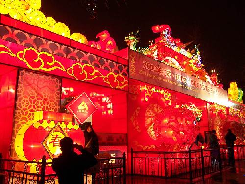 A visitor poses for pictures in front of lanterns at the Confucian Temple in Nanjing, Jiangsu Province, Feb. 11, 2010. The 2010 Jiangsu Qinhuai Lantern Fair also known as the 24th Confucian Temple Spring Festival Lantern Fair, kicked off in Nanjing on Thursday.